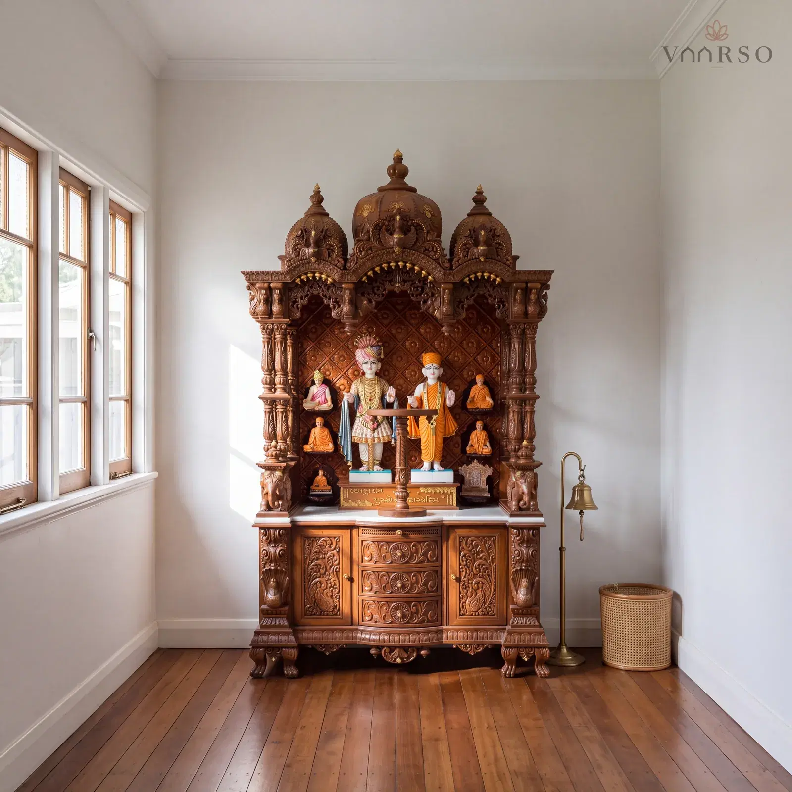 The same mandir in an enclosed verandah room, casement windows along one side, spotted gum boards underfoot and a brass bell on a floor stand and a cane basket beside it