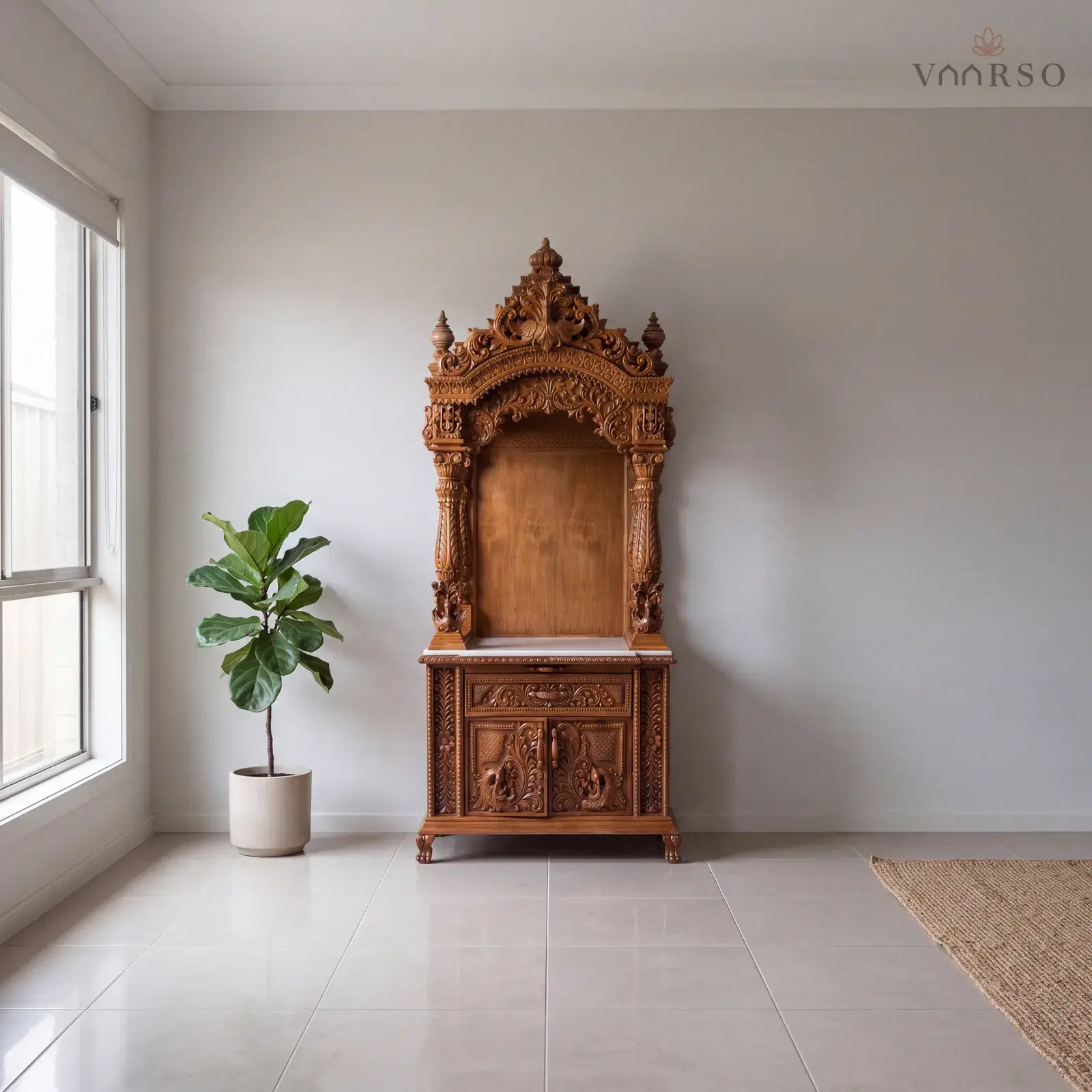 The same mandir in a quiet corner of an open-plan living room, a wide window to one side, sand-toned porcelain tile underfoot and a fiddle-leaf fig in a ceramic pot to one side